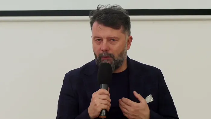 Rafał Szymański mówi do mikrofonu podczas debaty Fundacji Dajemy Dzieciom Siłę