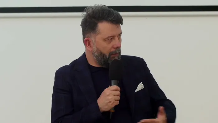 Rafał Szymański z mikrofonem podczas debaty FDDS, omawia sygnały ostrzegawcze kryzysu psychicznego u dziecka