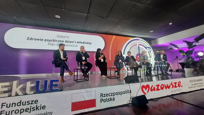 Scena debaty „Zdrowie psychiczne dzieci i młodzieży – plan dla Mazowsza” na 12. Forum Rozwoju Mazowsza, siedmioro uczestników na tle ekranu z tytułem debaty