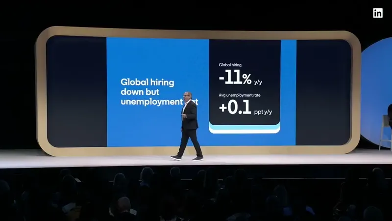 Dan Shapero on stage at Talent Connect 2026 in front of a slide reading Global hiring down but unemployment flat: global hiring down 11% year over year, average unemployment rate up 0.1 percentage points