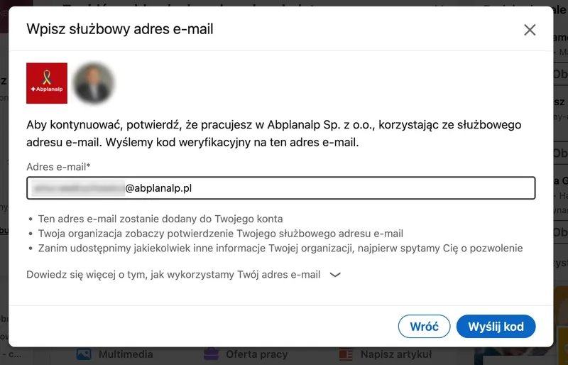 LinkedIn dialog in Polish asking the member to enter a work email address to confirm they work at the company, with a verification code sent to that address; the photo and the start of the address are blurred