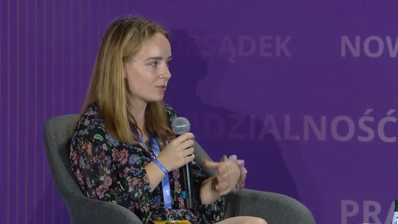 Angelika Friedrich speaking into a microphone and gesturing, seated in an armchair on the stage at Campus Polska Przyszłości