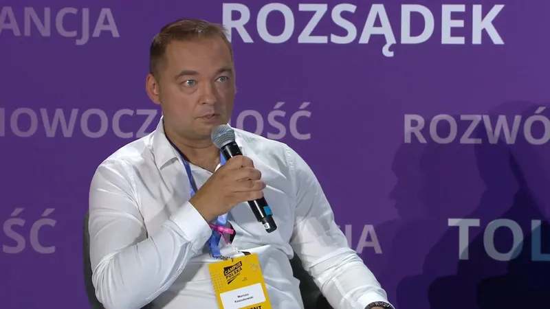 Dr. Mariusz Kaszubowski in a white shirt speaking into a microphone on the stage at Campus Polska Przyszłości