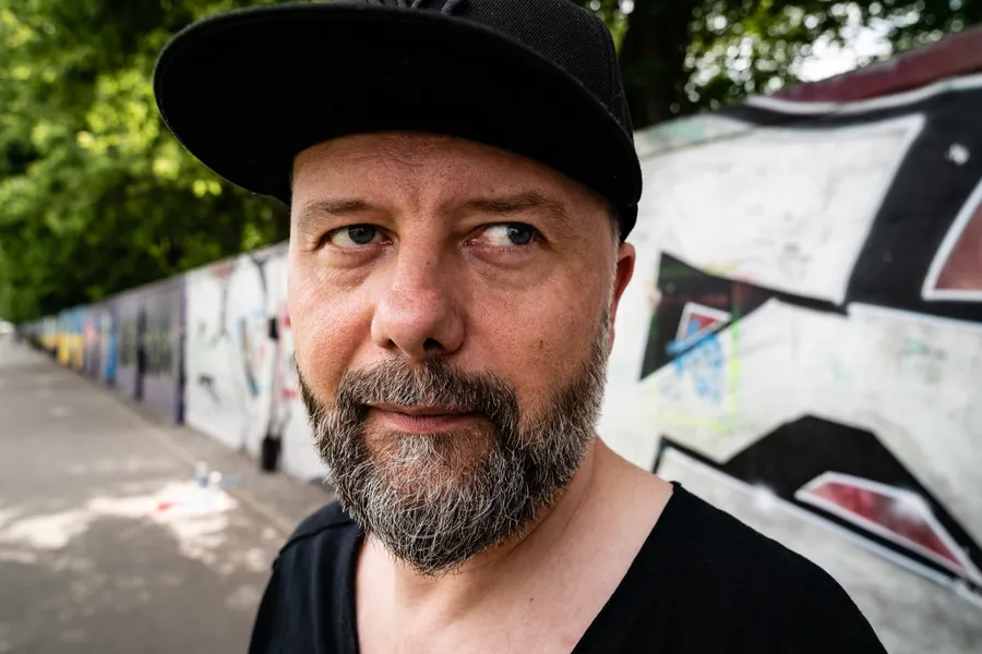 Rafał Szymański przy murze z graffiti na planie filmu „Nic nie czuję”